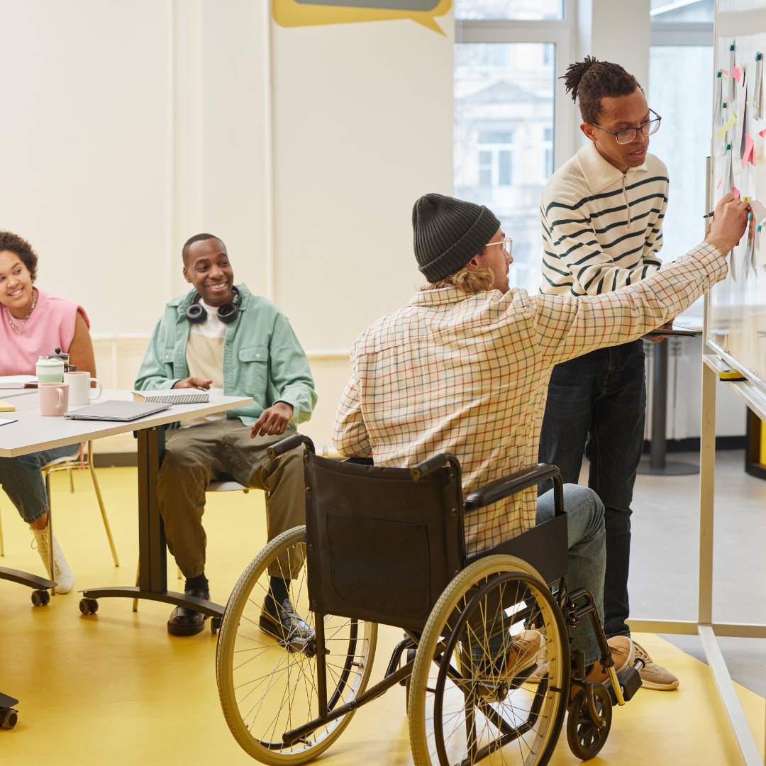 group of individuals collaborating, two write on white board 