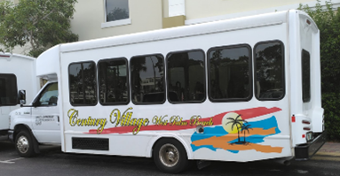 White accessible bus with text on the side that reads Century Village West Palm Beach