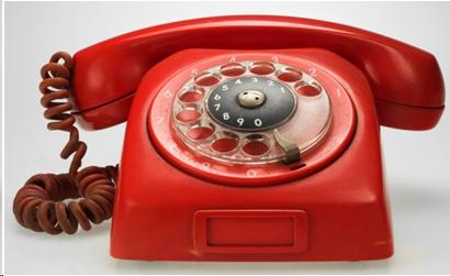 Photograph of a red rotary telephone.