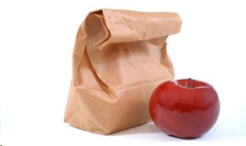 Photograph of a lunch bag and an apple sitting next to it.