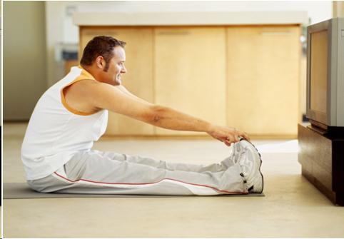 Photograph of someone working out to an excersize show on the television.